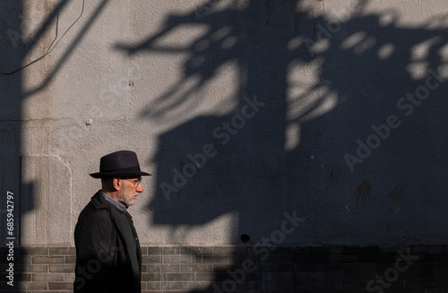 Side view of adult man in hat on street. Beijing, China