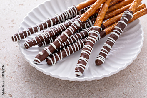 Chocolate dipped pretzel rods on a plate
