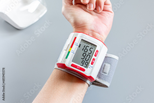 Hypertension. Tensiomètre de poignet. Automesure indiquant une tension artérielle de 16.9  photo