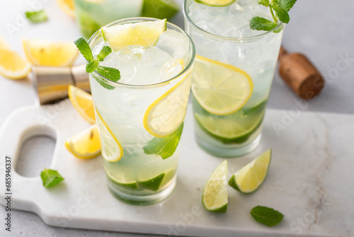 Lemon and lime mojito cocktail in tall glasses with lime and mint