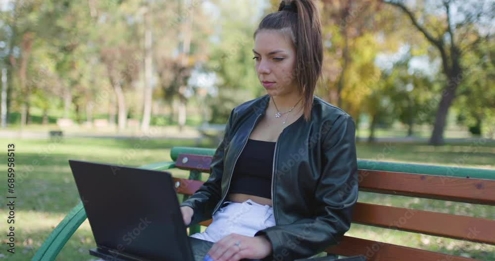 Portait of a fashionable young lady finishing a job on a laptop. Beautiful happy girl sitting on a bench in the park taking a deep breath. Portait of a fashionable young lady finishing a job on a laptop. Beautiful happy girl sitting on a bench in the park taking a deep breath.
