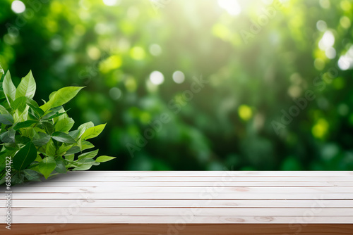 Empty old white wooden table or counter with a background of green leaves  ideal for displaying or montage of your products. Bright image. 
