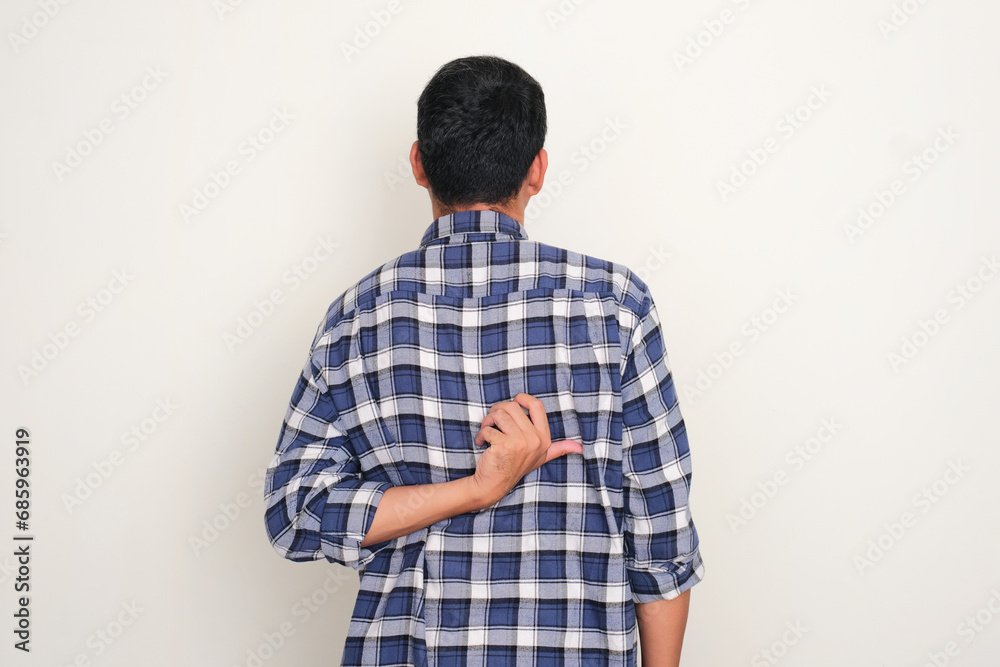 Back view of a man scratching his back with hand - obrazy, fototapety, plakaty 