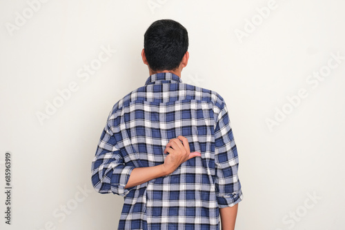 Back view of a man scratching his back with hand photo