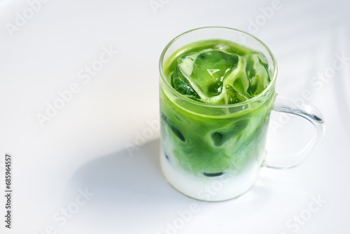 ice matcha green tea latte on white table.