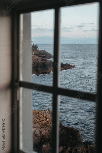 Ocean view through lighthouse window at sunset photo