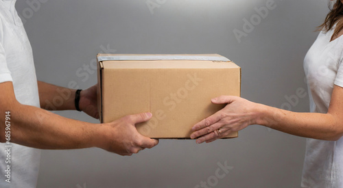 Close-up handover of package to woman at home © Head