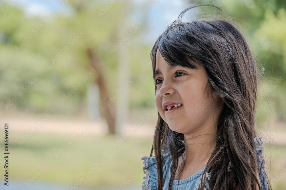 Beautiful little girl pictured in a park while talking. Beautiful little girl pictured in a park while talking.