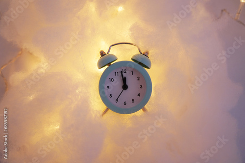 Blue retro alarm clock on a luminous cloud