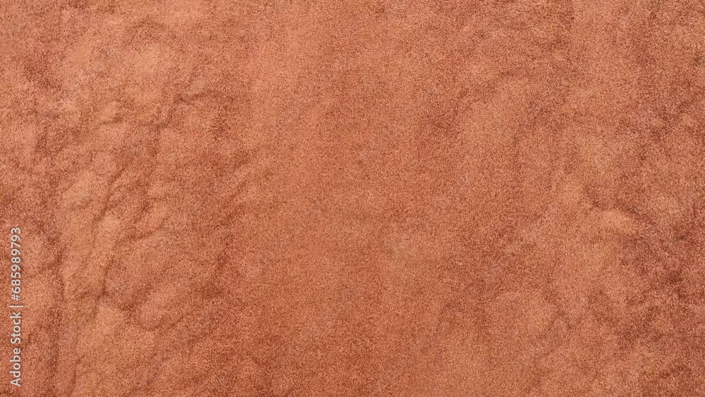 background of red sand flowing down dunes in the desert. The sand is pouring down