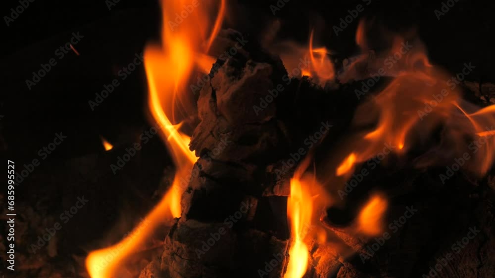 Incredibly beautiful bonfire flame in slow motion. Flames on a wooden log in a bonfire at night. Active lifestyle, traveling, hiking and camping concept. Campfire burning in slow motion. Incredibly beautiful bonfire flame in slow motion. Flames on a wooden log in a bonfire at night. Active lifestyle, traveling, hiking and camping concept. Campfire burning in slow motion.