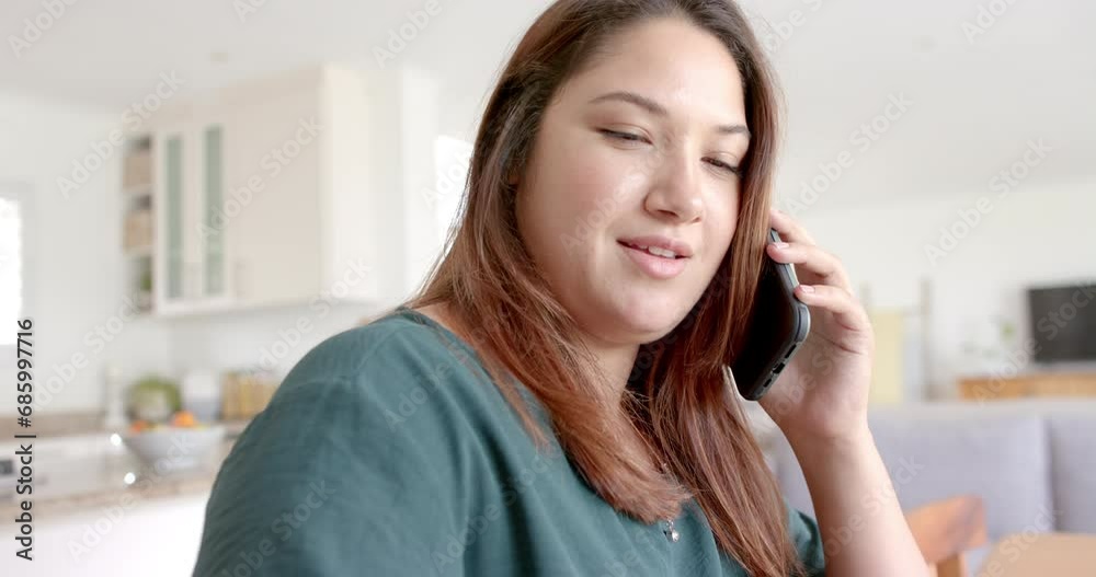 Happy plus size biracial woman talking on smartphone working from home, slow motion Happy plus size biracial woman talking on smartphone working from home, slow motion