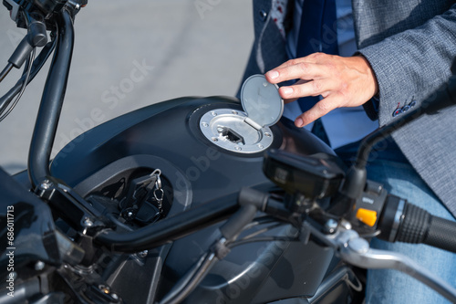 A man opened the charging socket on an electric motorcycle.