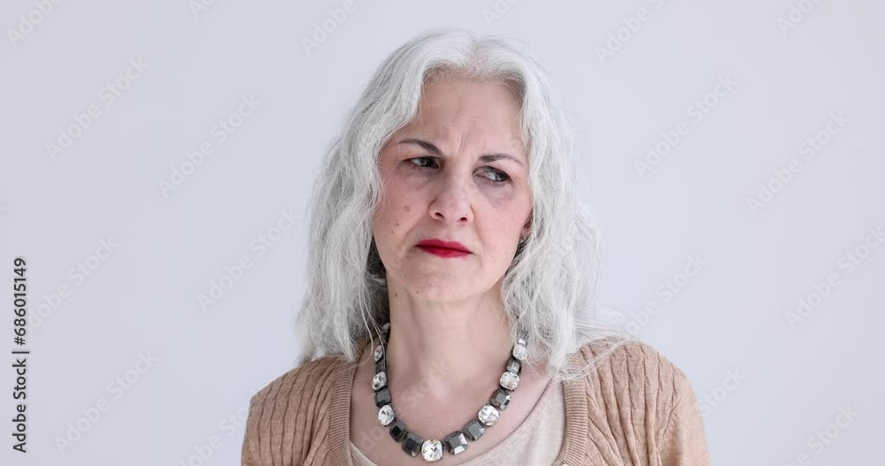 Sad elderly gray-haired woman is bored on white background portrait 4k movie. Problem of loneliness in elderly concept Sad elderly gray-haired woman is bored on white background portrait 4k movie. Problem of loneliness in elderly concept