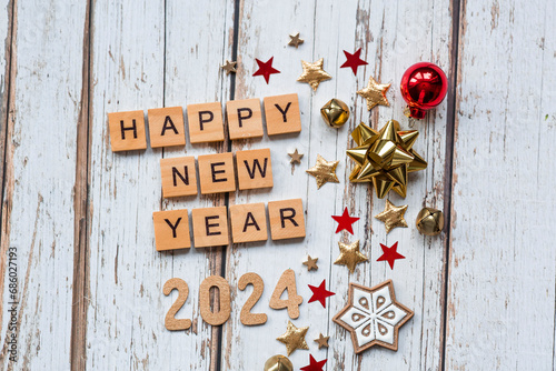 A postcard or banner.A symbol from the number 2024 with red Christmas tree toys, stars, sequins and a beautiful bokeh on a white wooden background. Happy New Year 2024.The concept of the celebration.