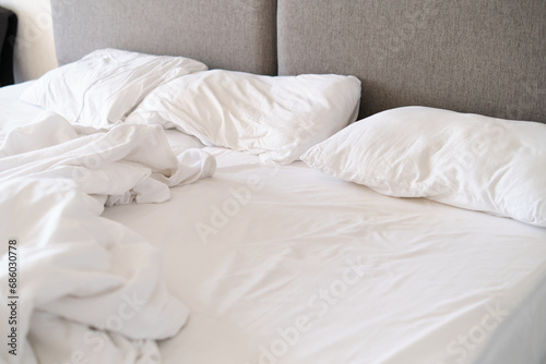 Unmade bed with white linens in soft light, suggesting morning. Speaks to the trend of authenticity in lifestyle imagery.