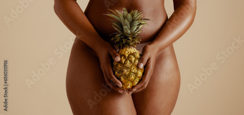 Body positivity: Sensual woman embracing wellness with pineapple photo