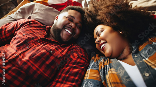 Portrait of a plus size black african american couple of a man and woman laying in bed displaying their affection for each other
