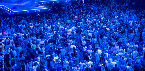 crowd of people at a concert in a huge concert hall