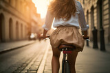 Eine Frau fährt mit dem Fahrrad durch die Stadt, von hinten fotografiert