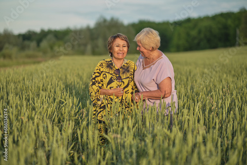 Two elderly women in a field, sharing a joke in the soft light of dusk. Symbolizes the importance of social interaction for mental health in aging.