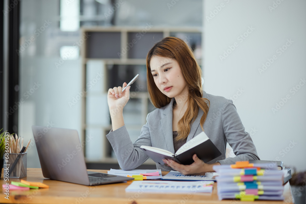 Businesswoman working with stack of documents papers and laptop sitting at office desk. Businesswoman working with stack of documents papers and laptop sitting at office desk.