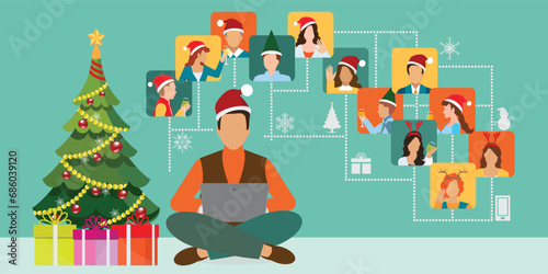 Young man in a New Year's hat sits near the Christmas tree