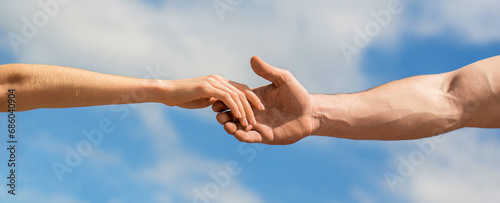 Solidarity, compassion, and charity, rescue. Hands of man and woman reaching to each other, support. Giving a helping hand. Lending a helping hand