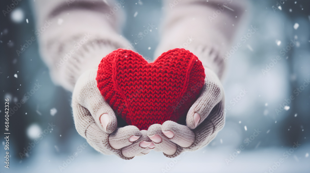 Red knitted heart in hands in winter Red knitted heart in hands in winter