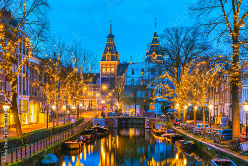 Amsterdam Netherlands canals with Christmas lights during December  canal historical center of Amsterdam at night in December during the Christmas holidays in the Netherlands