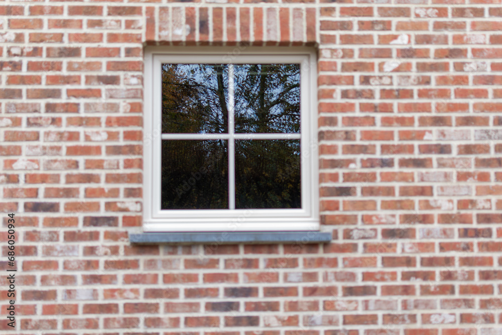 white window with reflection in the glass on a brick wall white window with reflection in the glass on a brick wall