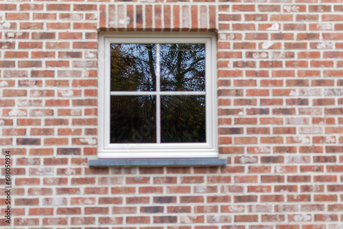 white window with reflection in the glass on a brick wall