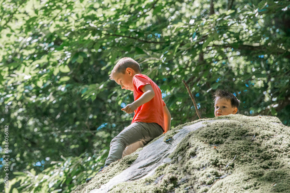 deux enfants jouant sur un rocher, en pleine nature
