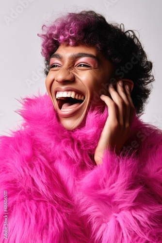 A male transvestite with light make-up and a pink fur coat laughs