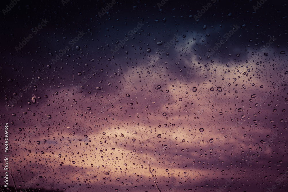 Raindrops on the glass against a restless sky. A shade of purple.