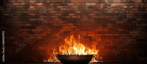 Fire burns in metal against brick wall Copy space image Place for adding text or design photo