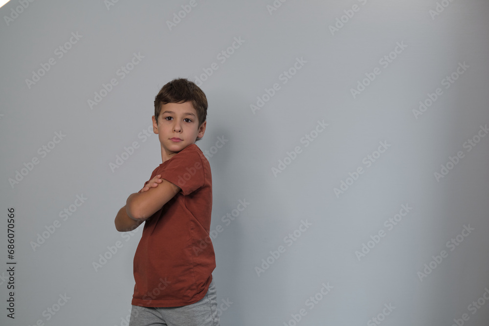 Arms crossed, a boy stands firm, showing determination. Reflects rising recognition of children's mental health awareness. Arms crossed, a boy stands firm, showing determination. Reflects rising recognition of children's mental health awareness.