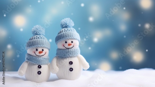 Little knitted snowmans on soft snow on blue background, copy space and generative ai © Nia™