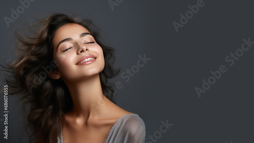 A brunette woman breathes calmly looking up isolated on gray background