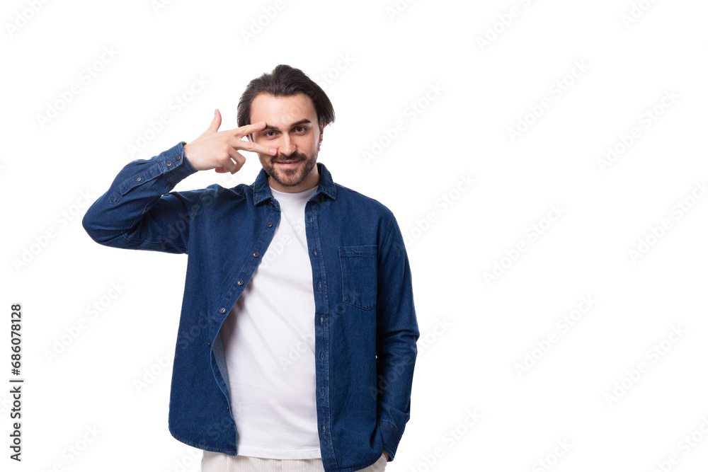 young well-groomed brunette guy in a casual blue shirt on a white coin with copy space young well-groomed brunette guy in a casual blue shirt on a white coin with copy space