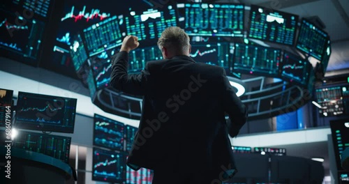 Successful Stock Exchange Trader Celebrating a Profitable Sale. Professional Broker Excited About the Good News, Punches the Air in a Winning Fashion, Showing Positive Emotions. View From the Back photo