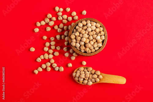 Chickpeas source of natural protein in wooden cup and spoon wooden on red background