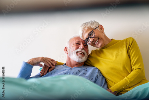 Mature couple in love. Happy senior woman visiting her husband in hospital ward. photo
