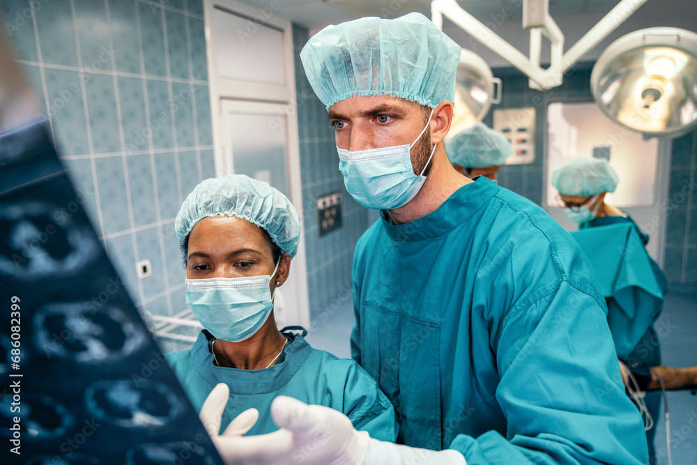 Medical doctors looking at x-rays in a hospital before operation. Healthcare, medical concept Medical doctors looking at x-rays in a hospital before operation. Healthcare, medical concept