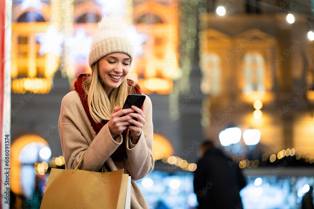 Shopper woman buying online on the smart phone at Christmas. People shopping communication concept Shopper woman buying online on the smart phone at Christmas. People shopping communication concept