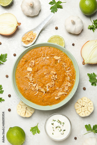 Sweet potato puree in bowl, onion, garlic and sauce on light background, top view