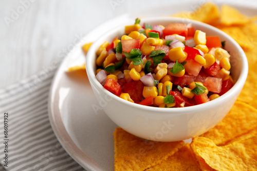 Homemade Corn Salsa with Tortilla Chips on a Plate, low angle view. Close-up.