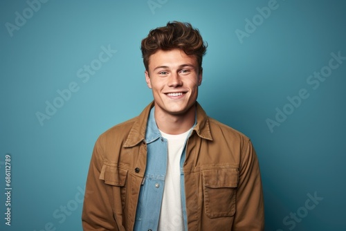Portrait of Young Photogenic Man Wearing Corduroy Jacket and Standing with Arms Crossed over Blue Studio Background