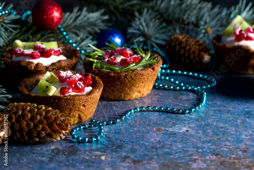 Christmas nut tartlets. Delicious, beautiful cupcakes are decorated with Christmas garlands and Christmas tree branches. Selective focus. Copy space