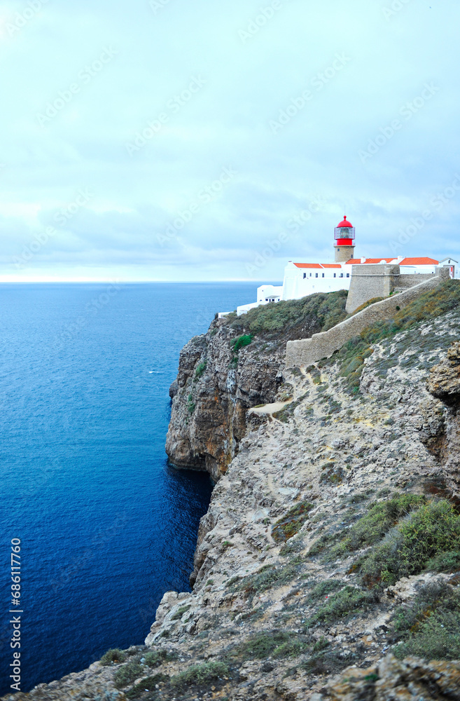 Red lighthouse on cliffs at Cape St. Vincent. Algarve, Portugal. The most extreme geographical point in the southwest of Continental Europe